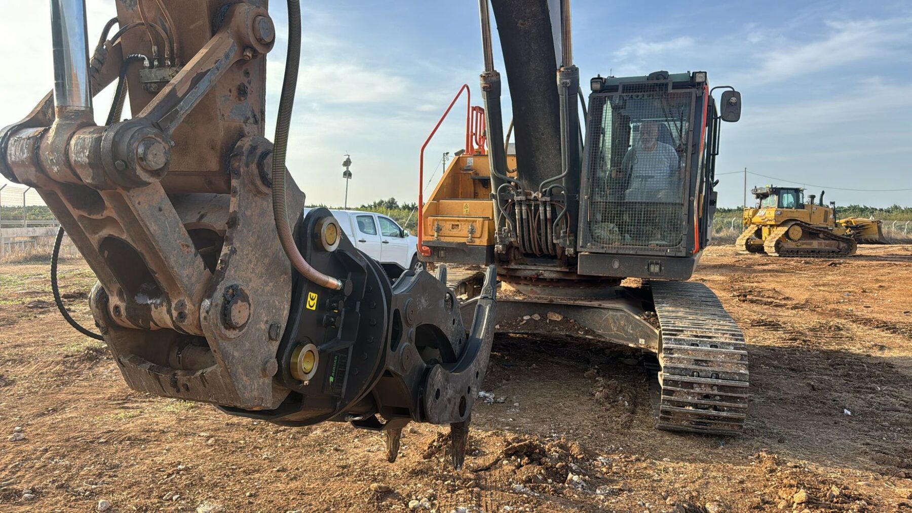 Volvo excavator with demolition shear, CAT dozer behind