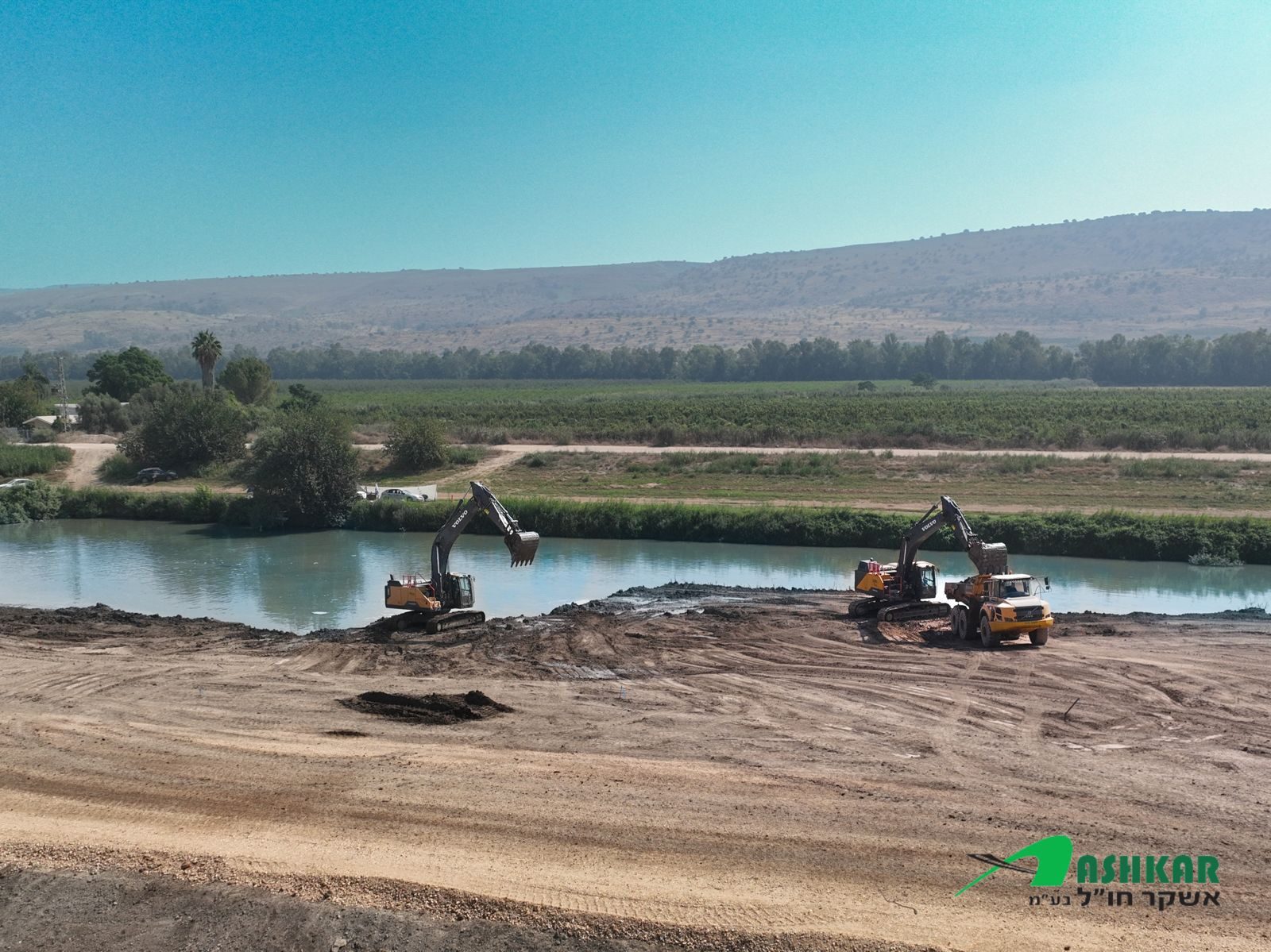 Two Volvo excavators working on a river bank in northern Israel
